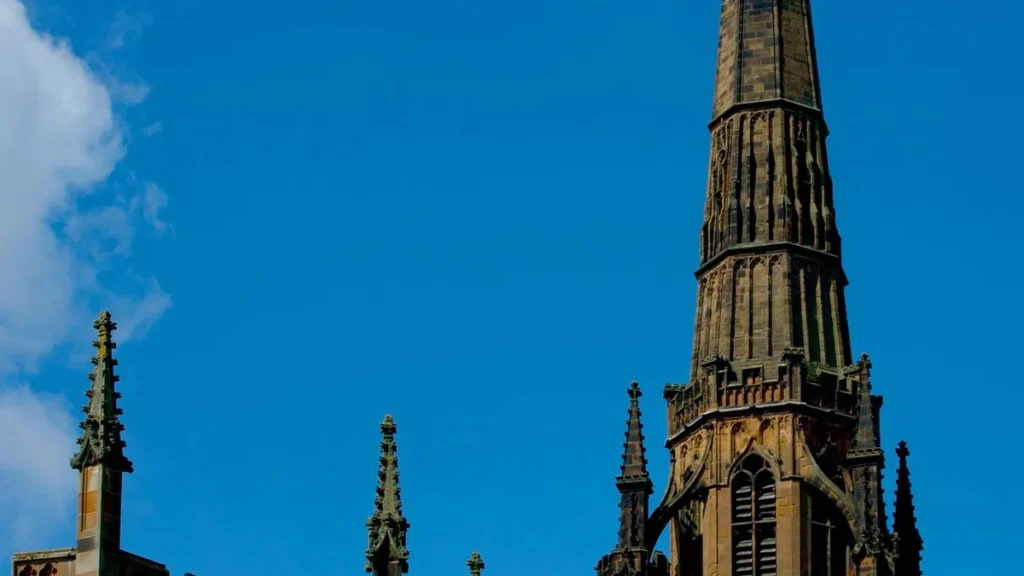 The spire of Coventry Cathedral against a blue sky, close to Esho Stays contractor accommodation in Coventry