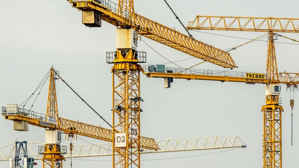 Several yellow tower cranes over a large construction site, the kind of project that needs group accommodation for contractors
