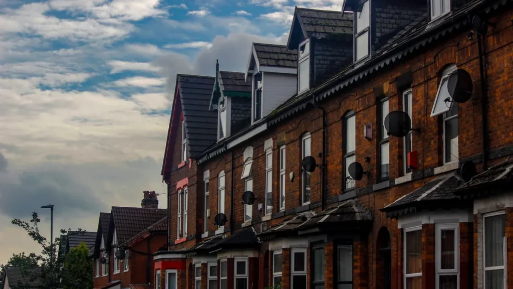 A row of red-brick Victorian terraced houses under an evening sky, typical of long-term contractor accommodation in English towns
